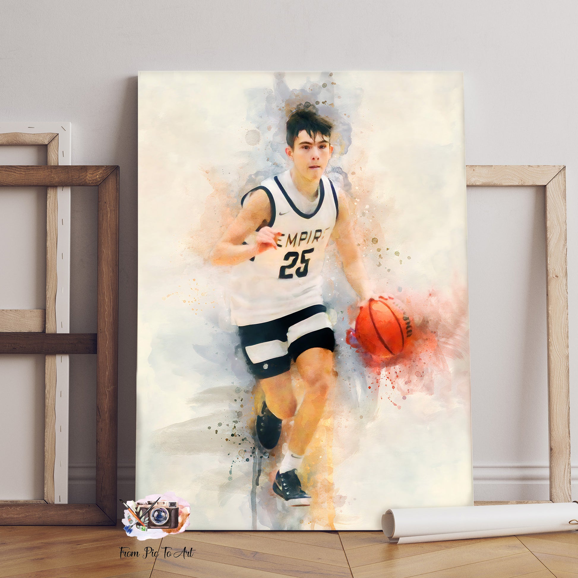 A dynamic watercolor-style portrait of a young male basketball player in a white and black "EMPIR 25" jersey, dribbling an orange basketball. The artwork is presented as a Custom Basketball Gift, with a subtle "From Pic To Art" logo in the bottom left corner, surrounded by two empty wooden frames and a rolled-up poster.