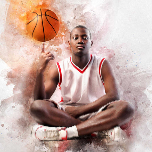A focused young male basketball player sits cross-legged in a white jersey with red trim, balancing a basketball on his finger. The image is a Custom Basketball Gifts item, with a watercolor or artistic filter applied, featuring an abstract, splattered background in shades of orange, red, and white.