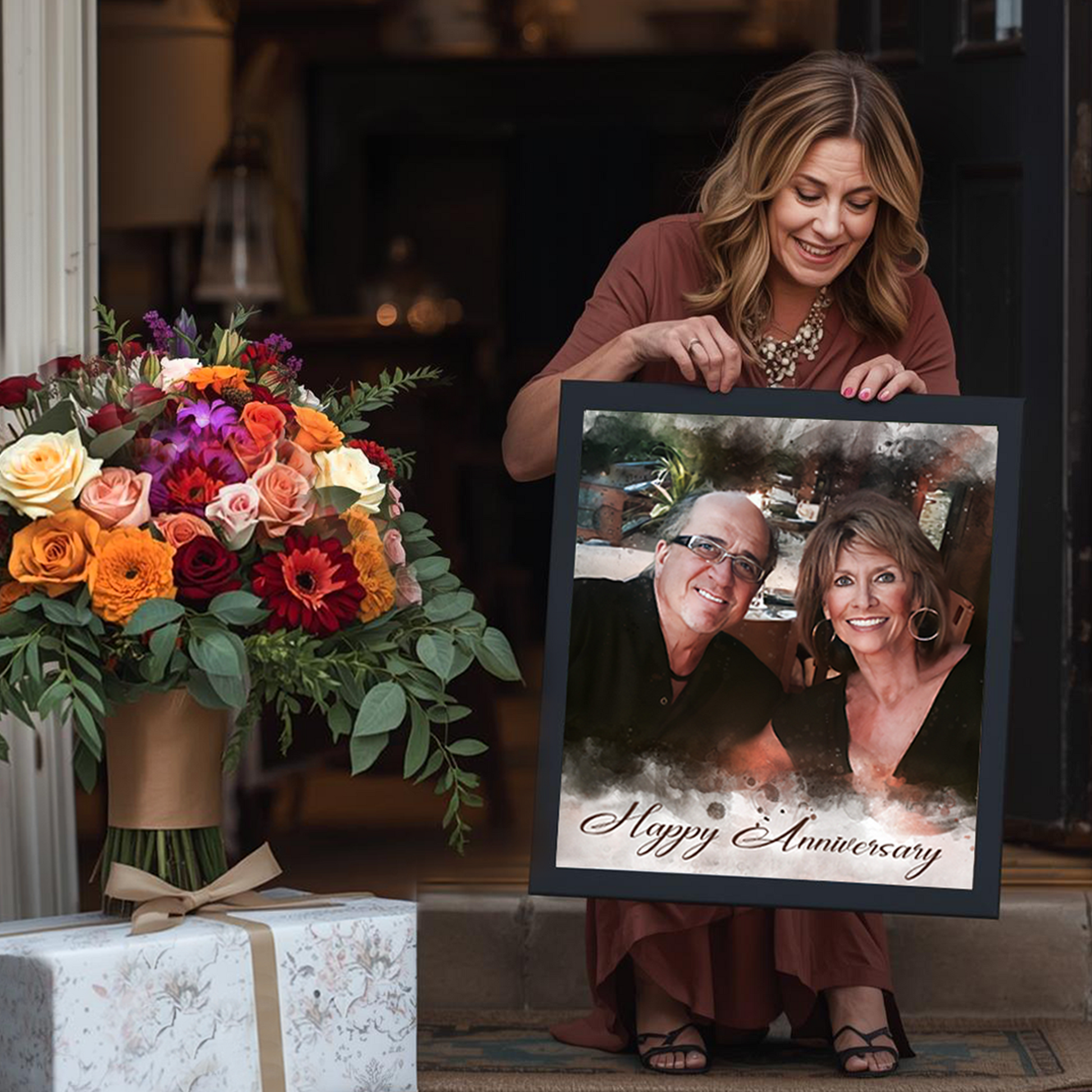 Woman holding a framed photo of two people with 'Happy Anniversary' text, surrounded by flowers and gifts.