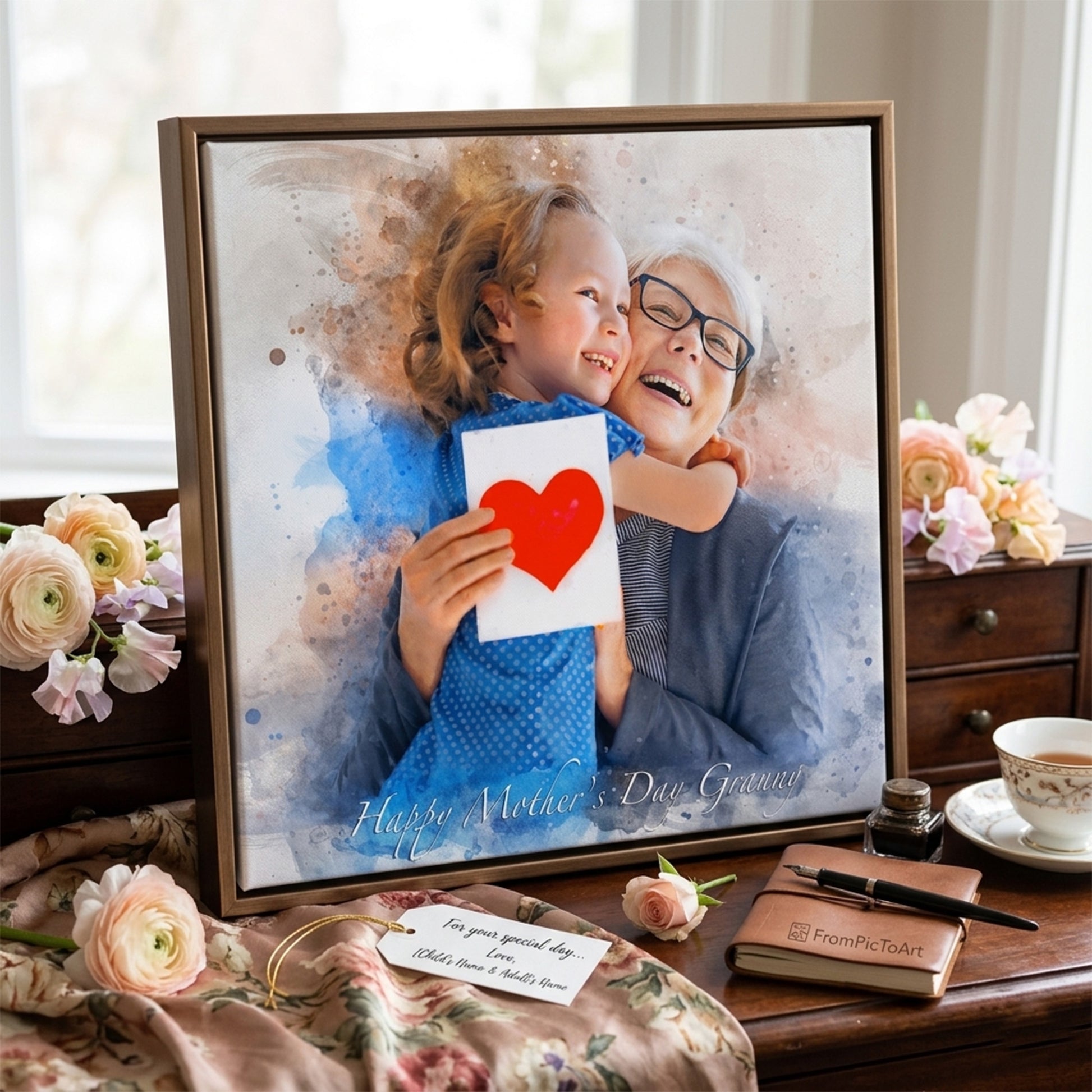 Framed photo of a child holding a heart card with an elderly person, surrounded by flowers and a cup on a wooden surface.